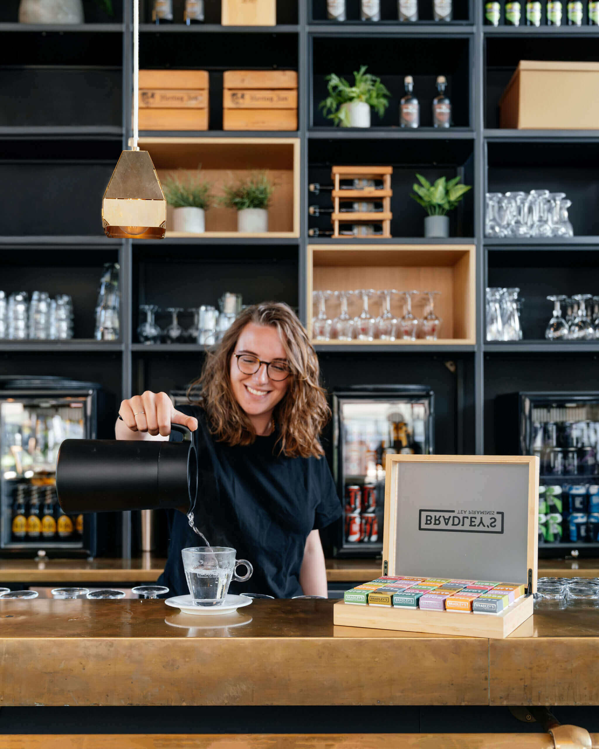 Bradley’s Fairtrade thee geserveerd in een stijlvol kopje op een houten tafel in een gezellige horecasetting.